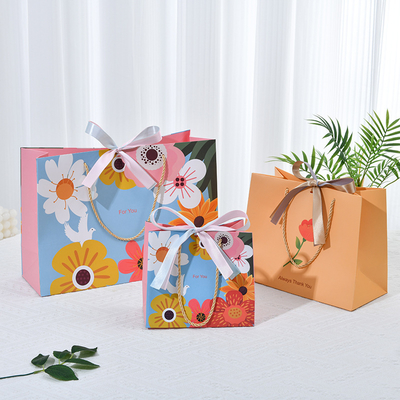 ​​Premium Floral Gift Bag With Gold Twine Handles Chic Bow Vibrant Blue Multicolor Bloom Design